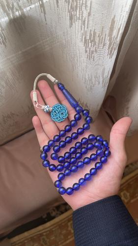 A blue transparent plastic rosary with a copper ce...