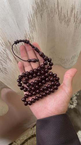 A brown-colored prayer bead with a tear-shaped pen...