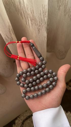 A prayer bead with a grayish color (concrete) Kark...