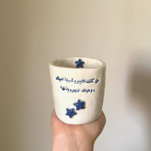 كوب بعبارة ( هل كانت النجوم شبيهة لعيناك أم عيناك...