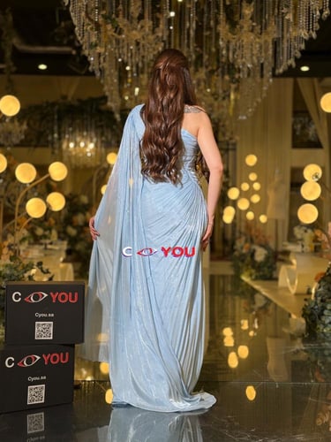 فستان سهرة سماوي بكتف واحد وكاب متدفّق بقصّة حورية...