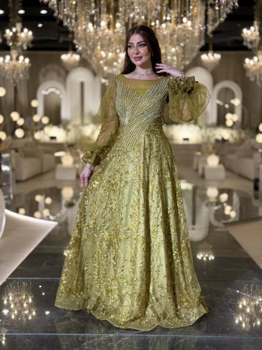فستان سهرة كُركُمي مطرّز فخم بقصّة وأكمام تول شفاف...