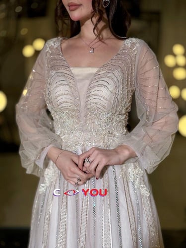 فستان سهرة شامبين فضي مطرز بتصميم فاخر وأكمام تول...
