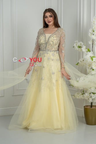 فستان سهرة أصفر باستيل مطرز بالترتر مع أكمام شفافة...