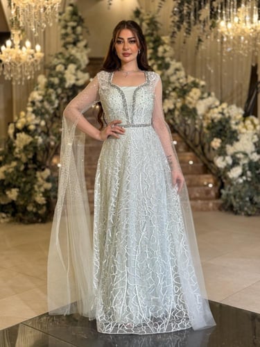 فستان سهرة بلون أخضر ثلجي بقصة مع كاب شفاف مرصّع و...