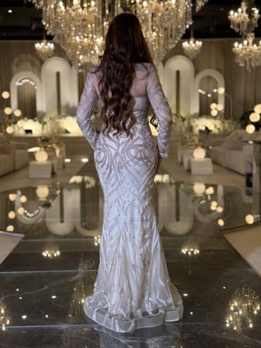 فستان سهرة أوف وايت مطرّز كريستالات بأكمام شفافة و...