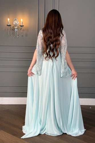 فستان سهرة سماوي انسيابي مزدان بكريستالات براقة وك...