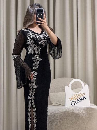 فستان سهرة أسود بتطريز فضي فاخر وأكمام شفافة بقصّة...