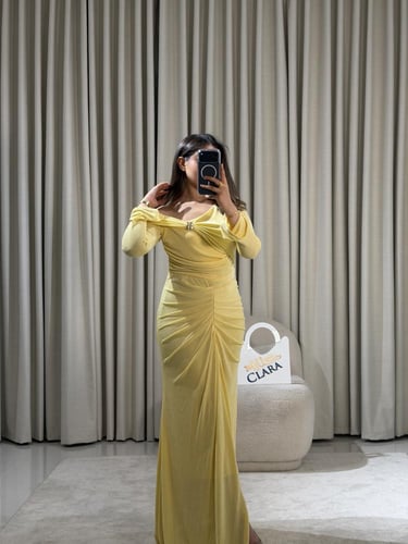 فستان أنثوي بقصة كتف مكشوف وتفاصيل درابيه راقية