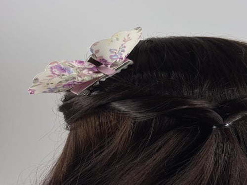 توكات على شكل فيونكة جلد أبيض مشجر بورود بنفسجي و...