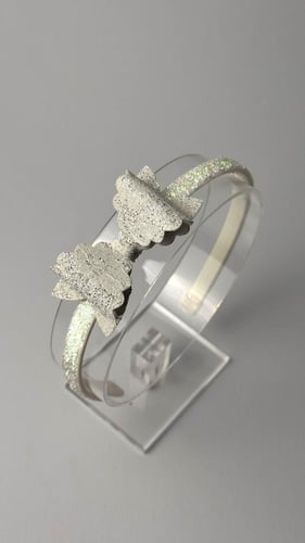 طوق بلاستك مزين بفيونكة جلد أبيض وفضي