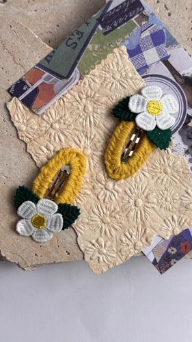 توكات صفراء مزينة بوردة بيضاء وأوراق خضراء