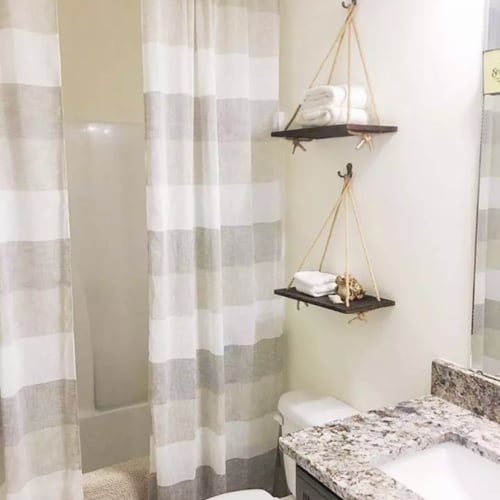 رف خشبي معلق بحبل شكل ارجوحة