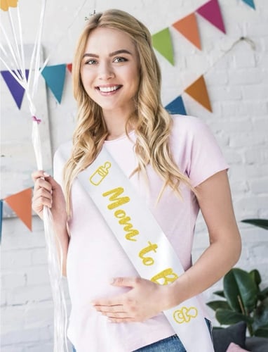 وشاح وبروش ابيض وذهبي للأم في حفل كشف جنس الحنين