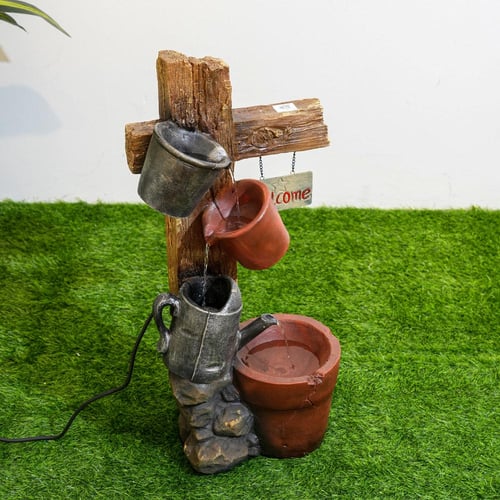 نافورة مياه علي شكل لوح خشبي مثبت عليها اباريق مقا...