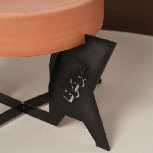 صحن تقديم فخار بقاعدة معدن بعبارة (نورتونا) لون اس...