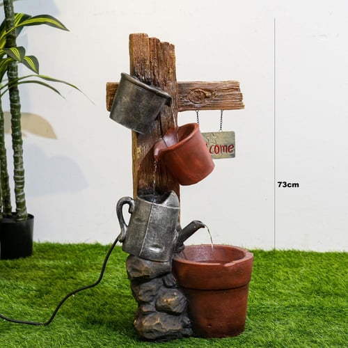 نافورة مياه علي شكل لوح خشبي مثبت عليها اباريق مقا...