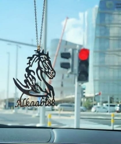 تعليقة سيارة بالاسم مع رسمه خيل وعبارة استودعتك ال...