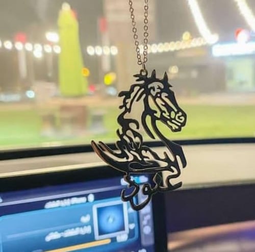 تعليقة سيارة بالاسم مع رسمه خيل وعبارة استودعتك ال...