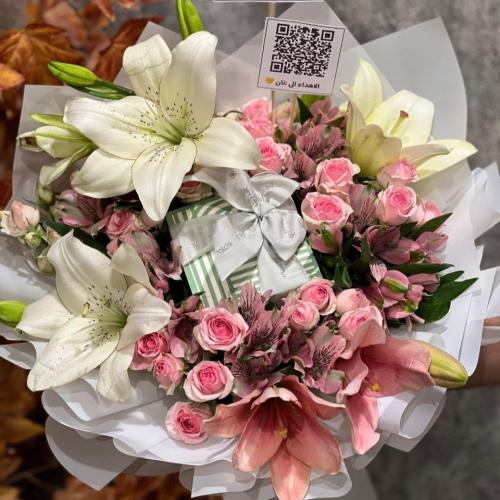 شوكولاتة باتشي وسط بوكيه ورد جوري أحمر مغلف بتغليف...