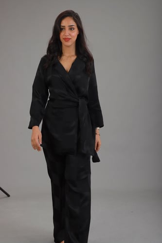 بلوزة سوداء مع ربطة أنيقة وبنطلون بلون موحد