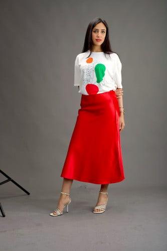 تي شيرت أبيض بطبعات ملونة وتنورة ميدي حمراء زاهية