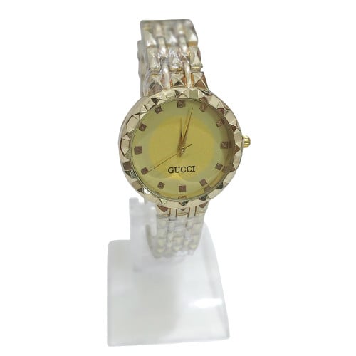 ساعة ذهبية بخلفية اصفر ذهبي بتصميم مستوحى من قوتشي