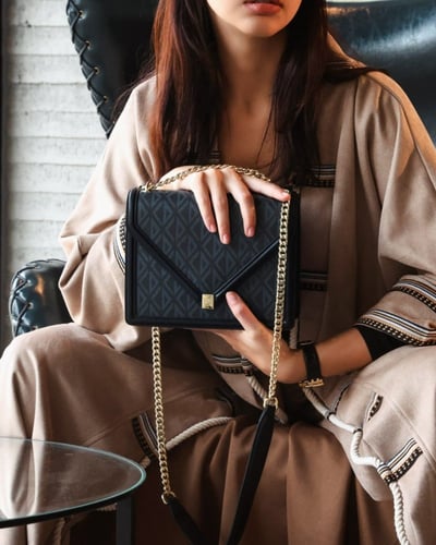 ‎ شنطة نسائية بتصميم أنيق بلون أسود.