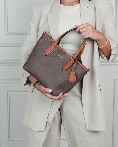 شنطة نسائية بمقاس متوسط بلون بني.