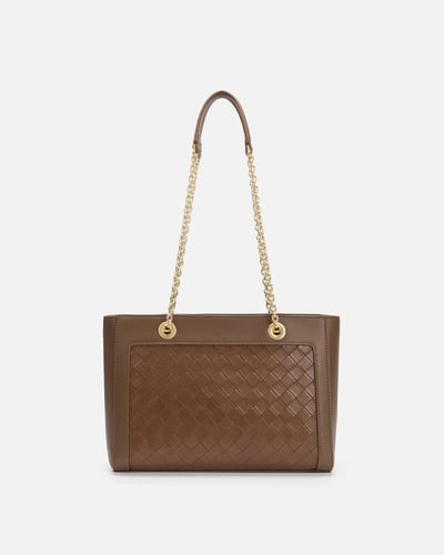 شنطة بتصميمها الواسع من الجلد بلون بني