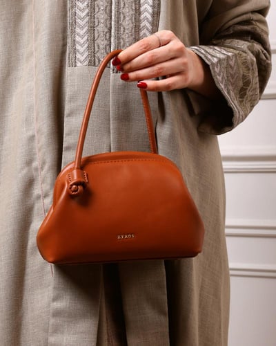 شنطة نسائية كقطعة فنية من الجلد بلون بني