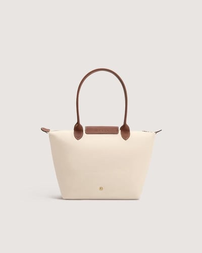 ‎ شنطة نسائية بحجم متوسط بلون بيج.