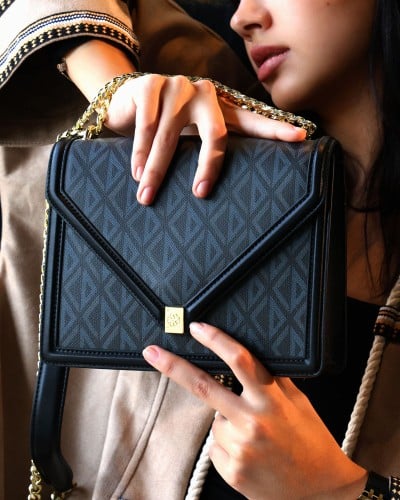 ‎ شنطة نسائية بتصميم أنيق بلون أسود.