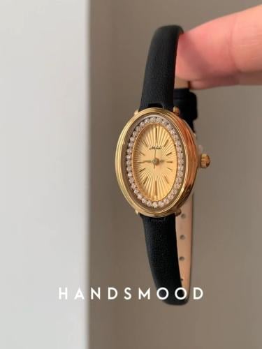 An oval-shaped watch encrusted with diamonds, stylish, remarkable, modern, women's watch made of genuine leather, specialized mood