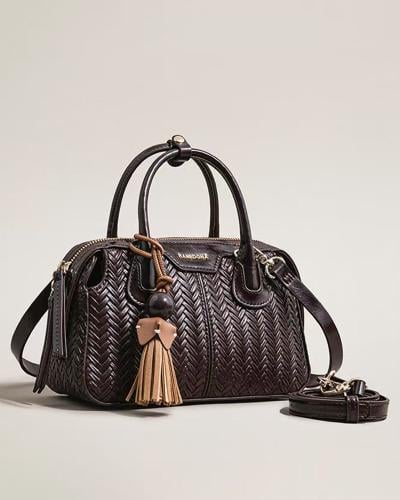 شنطة تصميمها الفريد باللون العودي بلحجم الصغير