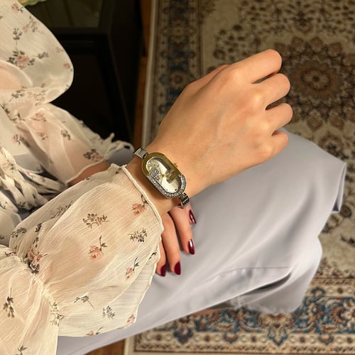 ساعة نسائية باللون الفضي والذهبي