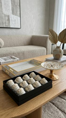 طقم ضيافة فاخر مكون من طقم صواني تقديم مع طقم فناجين قهوة وحامل تقديم حلويات بتصميم أنيق وعصري