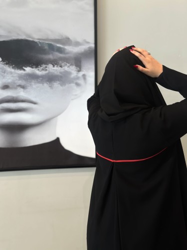 A black abaya made of crepe fabric with a slit at the back, half wide-leg.