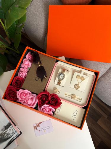 A complete women's gift set with a watch, perfume, sunglasses, accessories, and flowers