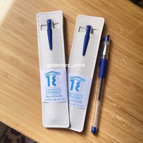 قلم أزرق بداخل حافظة جلد أبيض