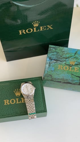 ساعه رولكس فضي من داخل ابيض مع ملحقاته