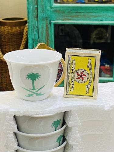 من البنود المميزة؛ درزن فناجيل بجودة عالية بشعار السيفين والنخلة من الجهتين بلون أخضر جميل ومميز؛ واضح حجم الفنجال مقارنة بعلبة ال...