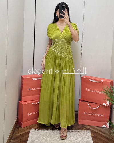 فستان سهرة أخضر طويل بقصة مميزة وطيات ناعمة