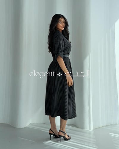 فستان أسود بأزرار أمامية وخطوط ناعمة