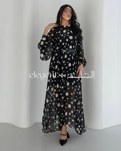 فستان أسود منقط أبيض بأكمام واسعة وأناقة عصرية