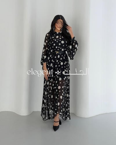 فستان أسود منقط أبيض بأكمام واسعة وأناقة عصرية