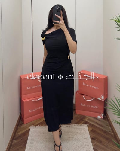 فستان سهرة ناعم أسود بكتف مائل وتفاصيل حلقات ذهبية