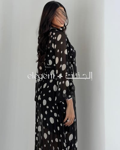 فستان أسود منقط أبيض بأكمام واسعة وأناقة عصرية
