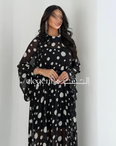 فستان أسود منقط أبيض بأكمام واسعة وأناقة عصرية