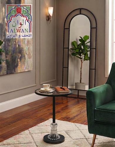 طاولة جانبية زجاجية سوداء بقاعدة معدنية وتفاصيل كر...